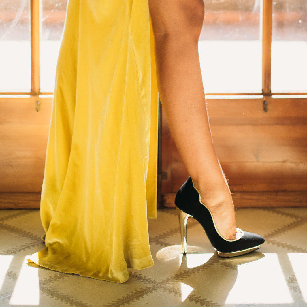 Miss Cavallier look de invitada de boda vestido amarillo y zapatos de tacón ondas con plataforma negro y dorado